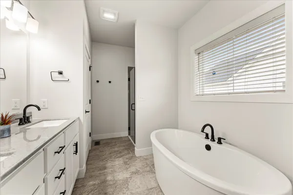 an empty room with ceiling fan and windows