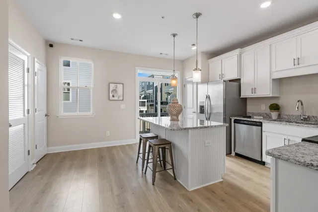 a kitchen with kitchen island granite countertop a table chairs microwave and cabinets