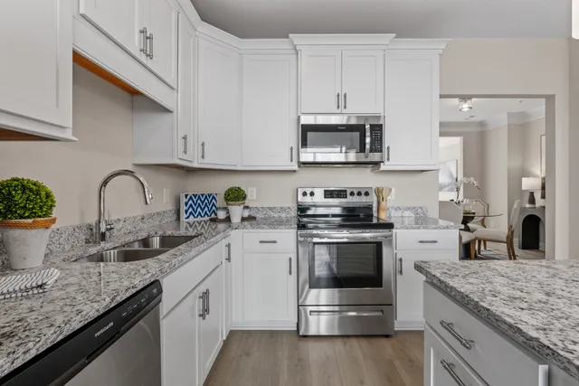 a kitchen with granite countertop a sink stove and refrigerator