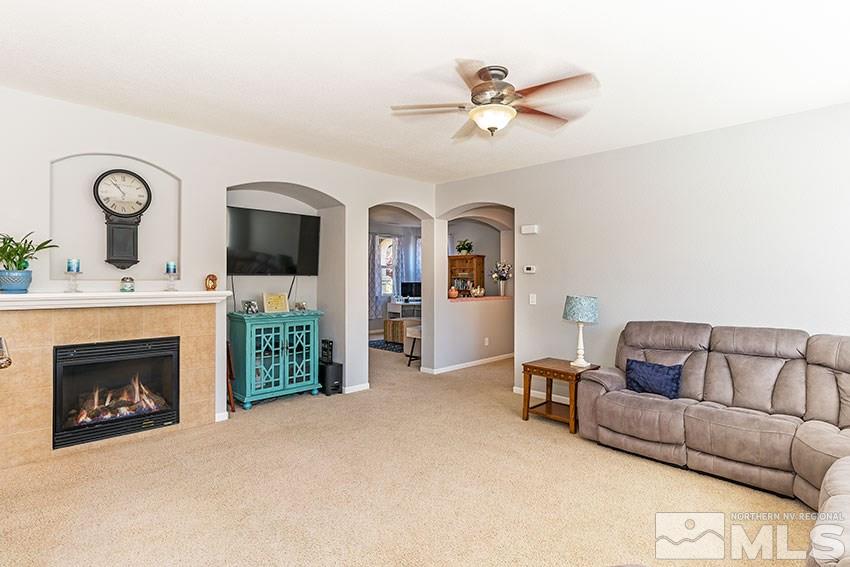 11190 Messina Way Reno, NV 89521 - Photo 6 of 21 a living room with furniture a fireplace and a flat screen tv