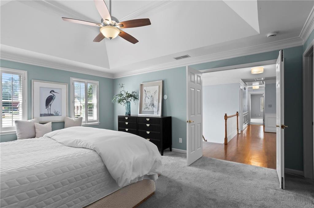 4350 Fallowfield Lane Southwest Lilburn, GA 30047 - Photo 21 of 64 a spacious bedroom with a large bed and a chandelier
