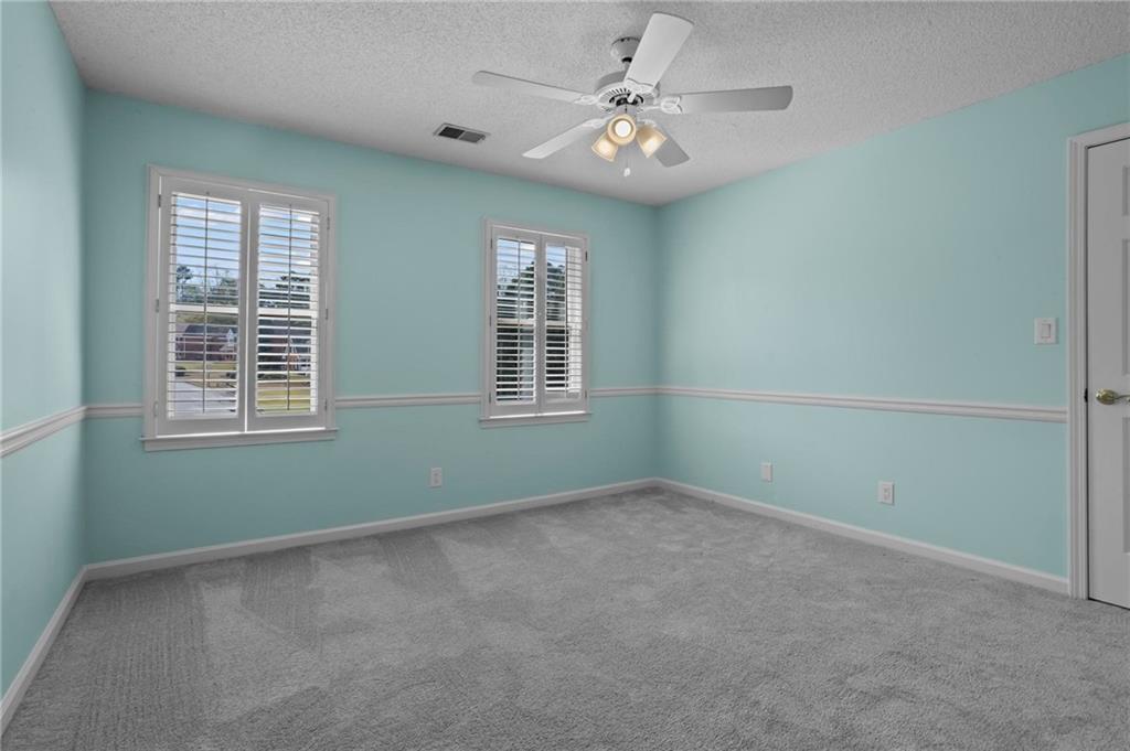 4350 Fallowfield Lane Southwest Lilburn, GA 30047 - Photo 26 of 64 an empty room with windows and fan