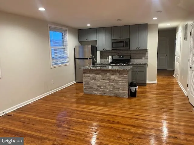 a kitchen with stainless steel appliances granite countertop a stove and a refrigerator