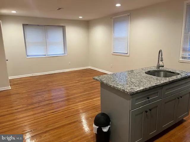 a kitchen with granite countertop sink and cabinets