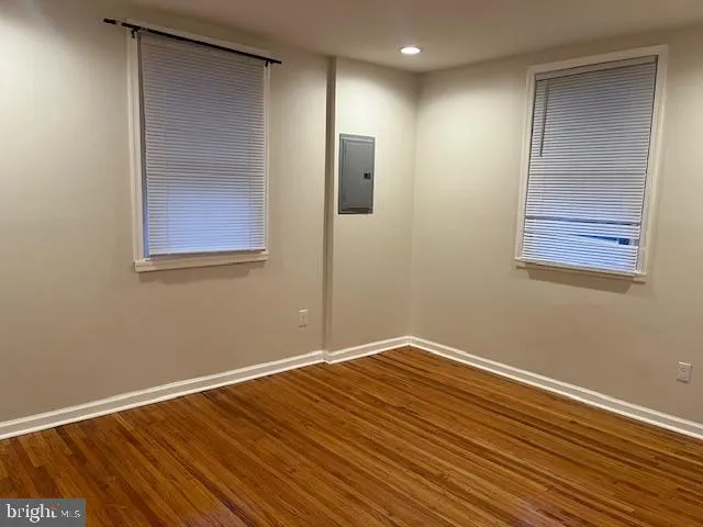 a view of empty room with wooden floor