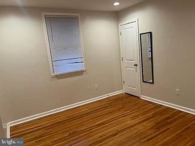 an empty room with wooden floor and closet