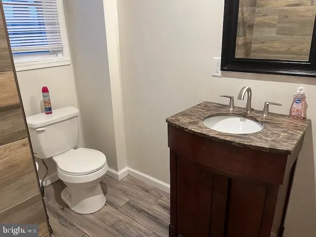 a bathroom with a granite countertop toilet sink and mirror