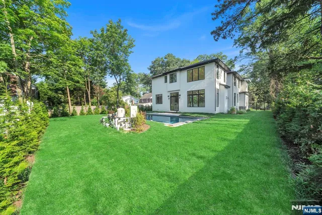 a view of backyard with swimming pool and green space