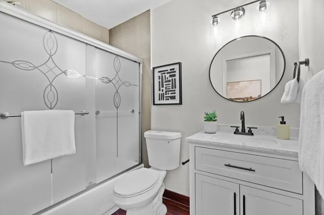 a bathroom with a sink mirror vanity and toilet