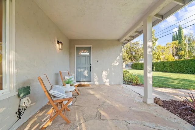 a view of a patio with table and chairs and floor to ceiling window