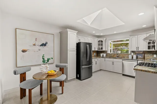 a kitchen with stainless steel appliances granite countertop a refrigerator and a sink