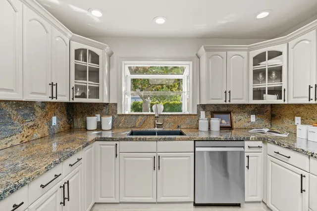 a kitchen with cabinets appliances a sink and a window