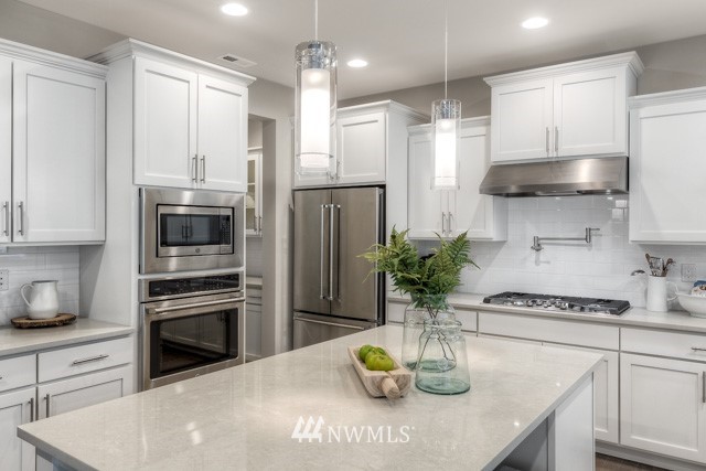 23226 7th Drive Southeast Bothell, WA 98021 - Photo 12 of 24 a kitchen with stainless steel appliances kitchen island granite countertop a refrigerator a stove a sink and white cabinets
