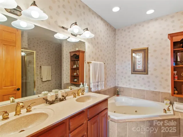 a bathroom with a tub a double vanity sink and a mirror