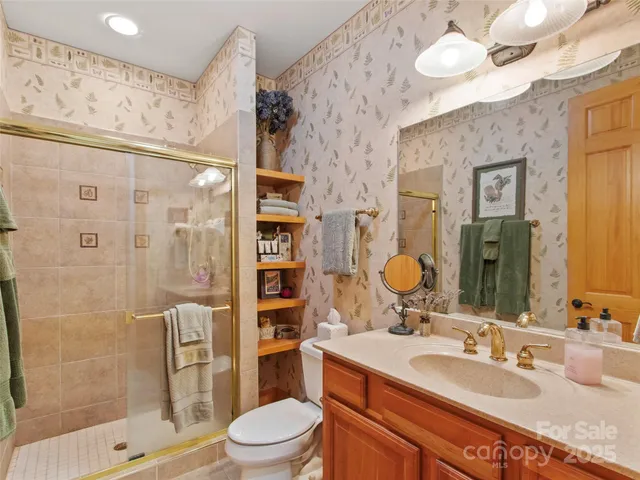 a bathroom with a granite countertop sink toilet and shower