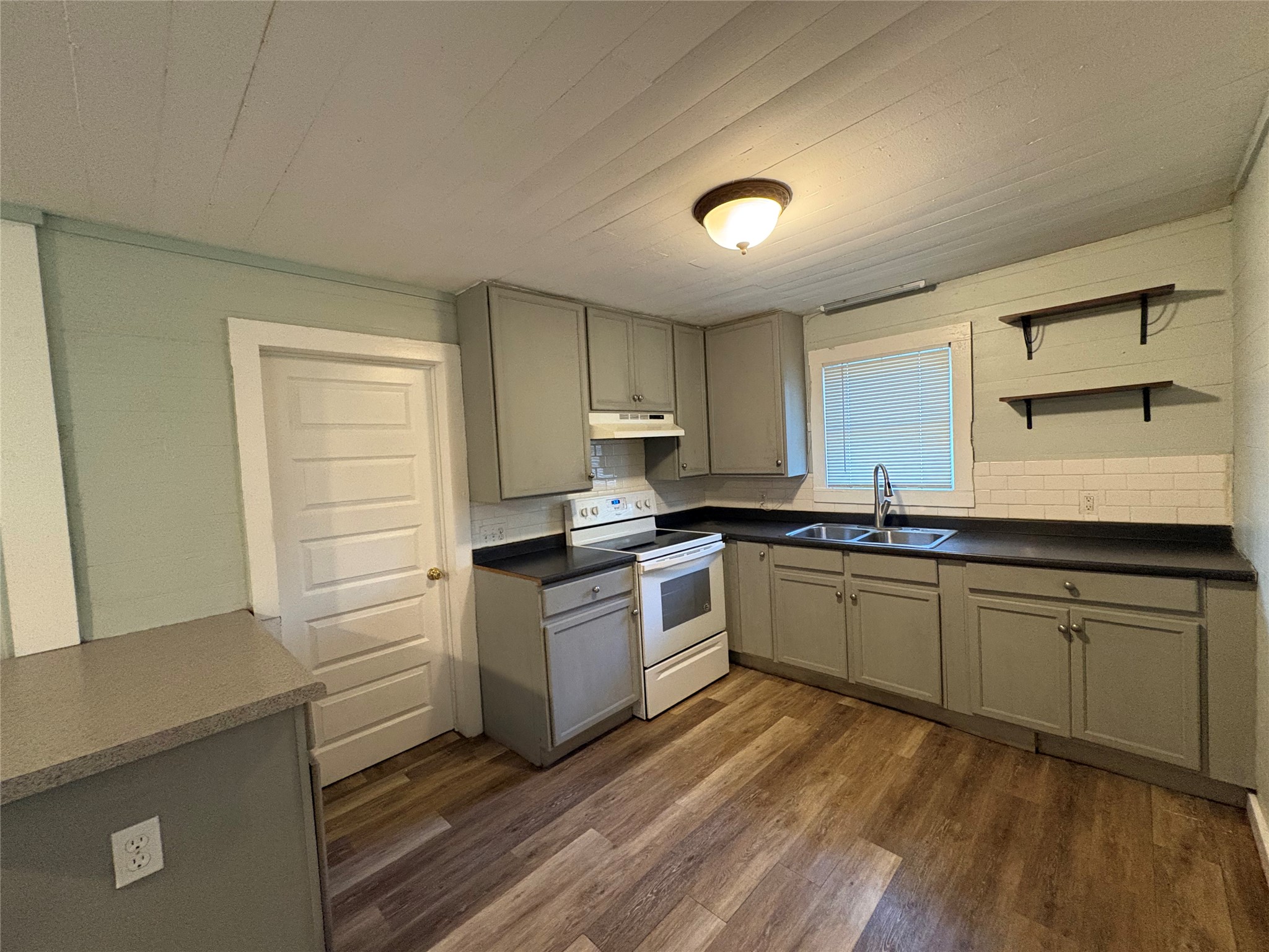 2305 Main Street Bastrop, TX 78602 - Photo 2 of 11 A functional kitchen provides ample storage and a cheerful window over the sink.