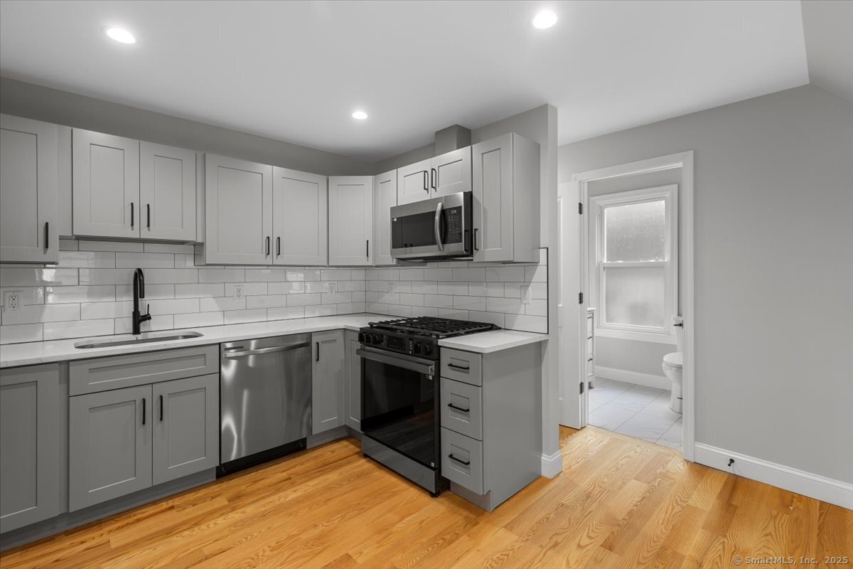 36 Maple Street, Unit 3 New Haven, CT 06511 - Photo 1 of 20 a kitchen with stainless steel appliances granite countertop a stove top oven a sink and dishwasher a refrigerator with wooden floor