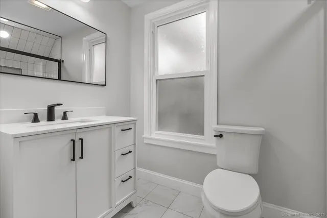 a bathroom with a toilet a sink and a mirror