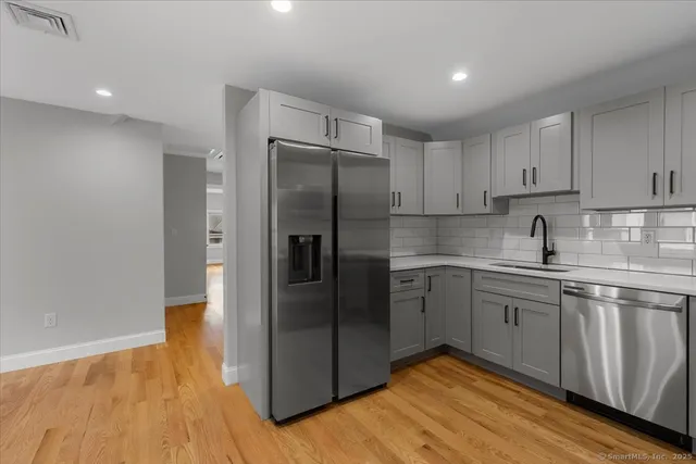 a kitchen with a refrigerator sink and cabinets