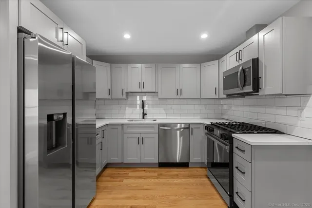 a kitchen with stainless steel appliances granite countertop a stove a sink and a refrigerator