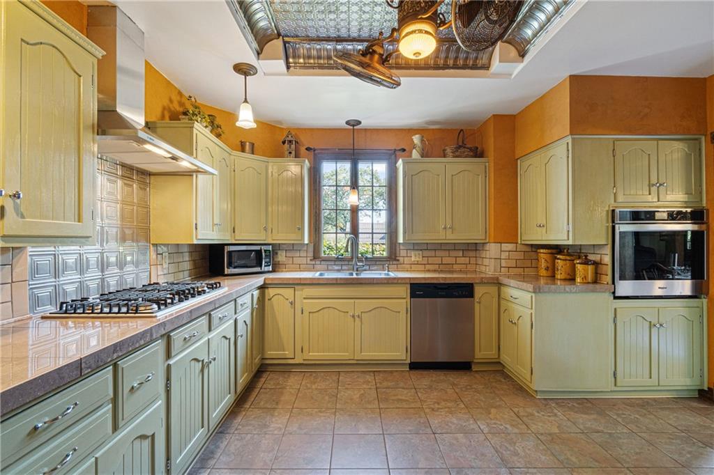 664 Hamilton Road Pittsburgh, PA 15205 - Photo 14 of 43 a kitchen with stainless steel appliances granite countertop a sink counter space cabinets and a large window