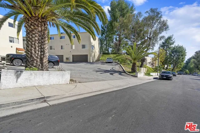 a view of a swimming pool with a lawn chairs under an umbrella