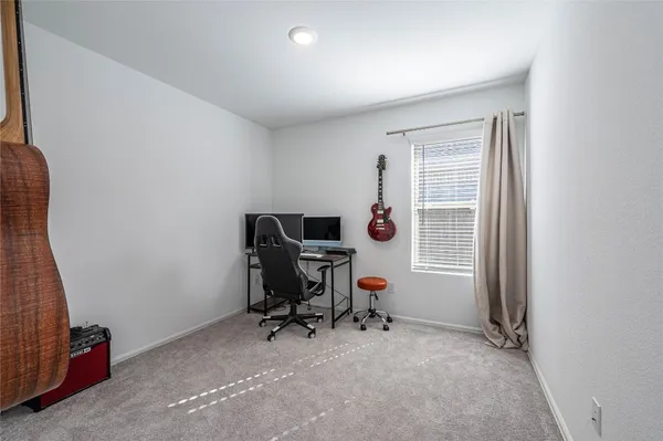 a view of a workspace with furniture and a window