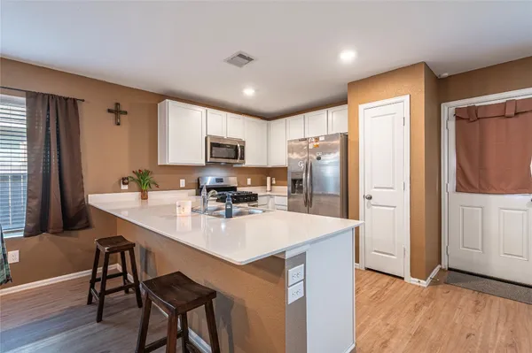 a kitchen with refrigerator cabinets and wooden floor