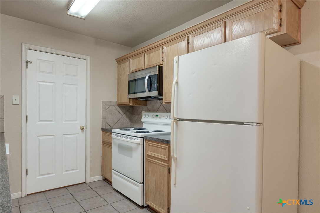 3606 Dustin Court, Unit B Killeen, TX 76549 - Photo 6 of 16 a white refrigerator freezer and a stove sitting inside of a kitchen
