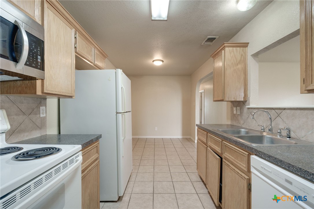 3606 Dustin Court, Unit B Killeen, TX 76549 - Photo 8 of 16 a kitchen that has a sink a stove and a refrigerator