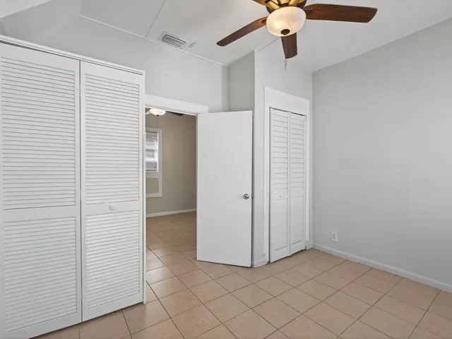 an empty room with fan and entryway