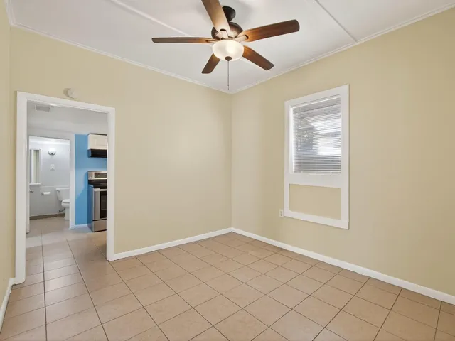 an empty room with fan and windows