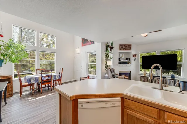 a large kitchen with sink a refrigerator and chairs