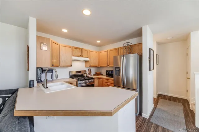 a kitchen with stainless steel appliances granite countertop a stove a sink and white cabinets
