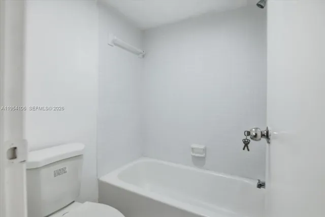 a white bath tub sitting next to a white toilet