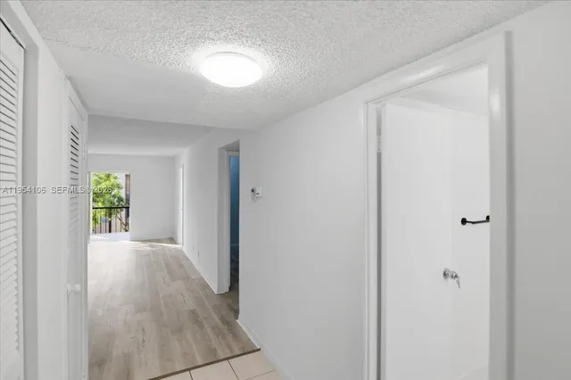a view of a hallway with wooden floor and a window