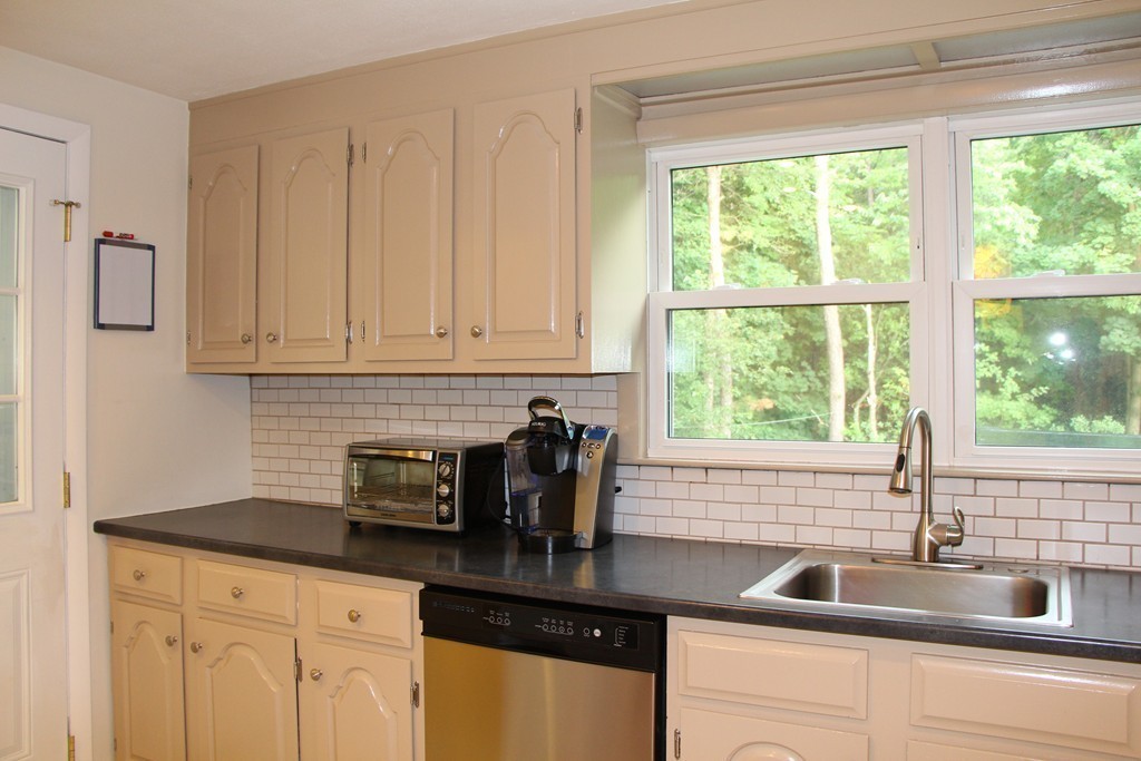 28 Deerfield Road Sharon, MA 02067 - Photo 6 of 20 a kitchen with granite countertop a sink white cabinets and a granite counter top