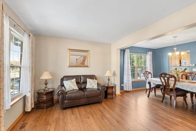 a view of a dining room with furniture a chandelier and wooden floor