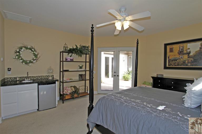 124 Loch Lomond Road Rancho Mirage, CA 92270 - Photo 18 of 25 a bedroom with a large bed and a chandelier