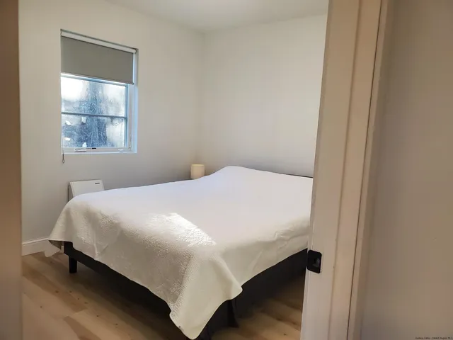 a bed sitting in a bedroom next to a window