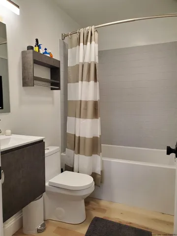 a white toilet sitting next to a bathroom sink and a shower