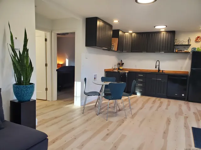 a kitchen with kitchen island granite countertop a sink cabinets and wooden floor