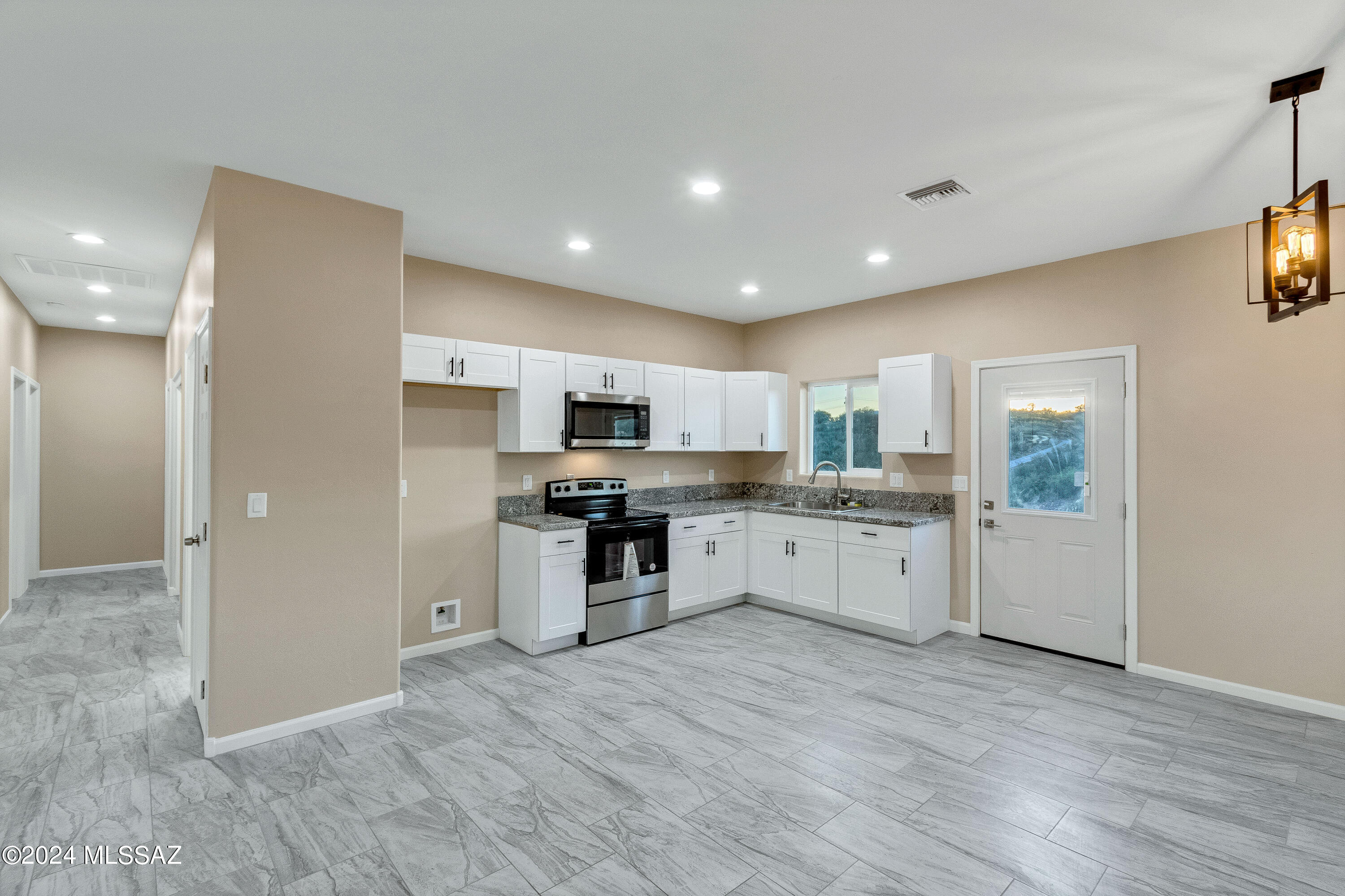 356 Globo Court Rio Rico, AZ 85648 - Photo 7 of 32 a large kitchen with a lot of counter space and stainless steel appliances