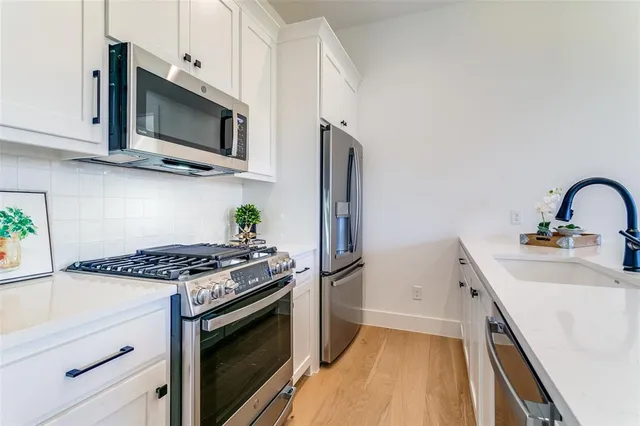 a kitchen with stainless steel appliances granite countertop a sink stove and microwave