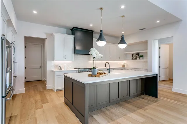 a kitchen with a sink a counter top space stainless steel appliances and a center island