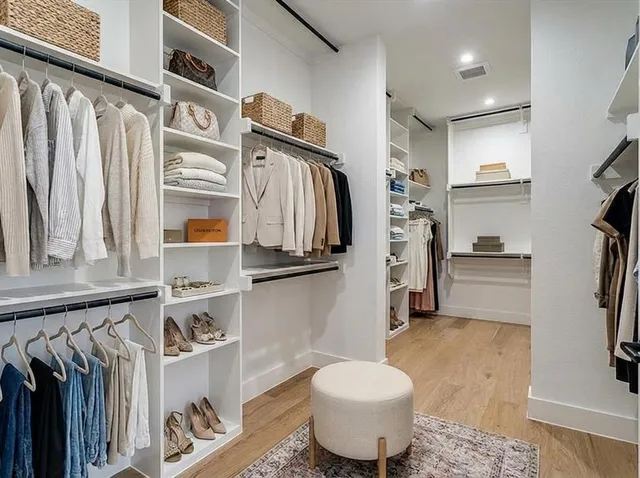 a view of walk in closet with clothes and shoes