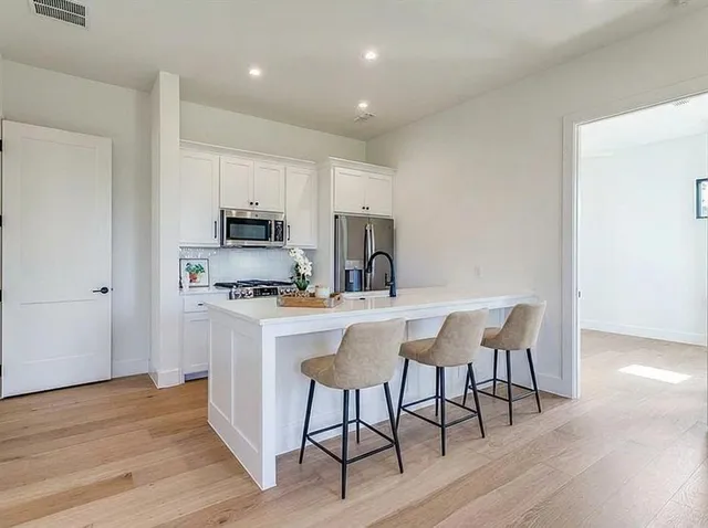 a kitchen with a sink a microwave a stove and cabinets