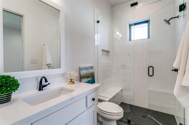 a bathroom with a sink toilet a mirror and shower