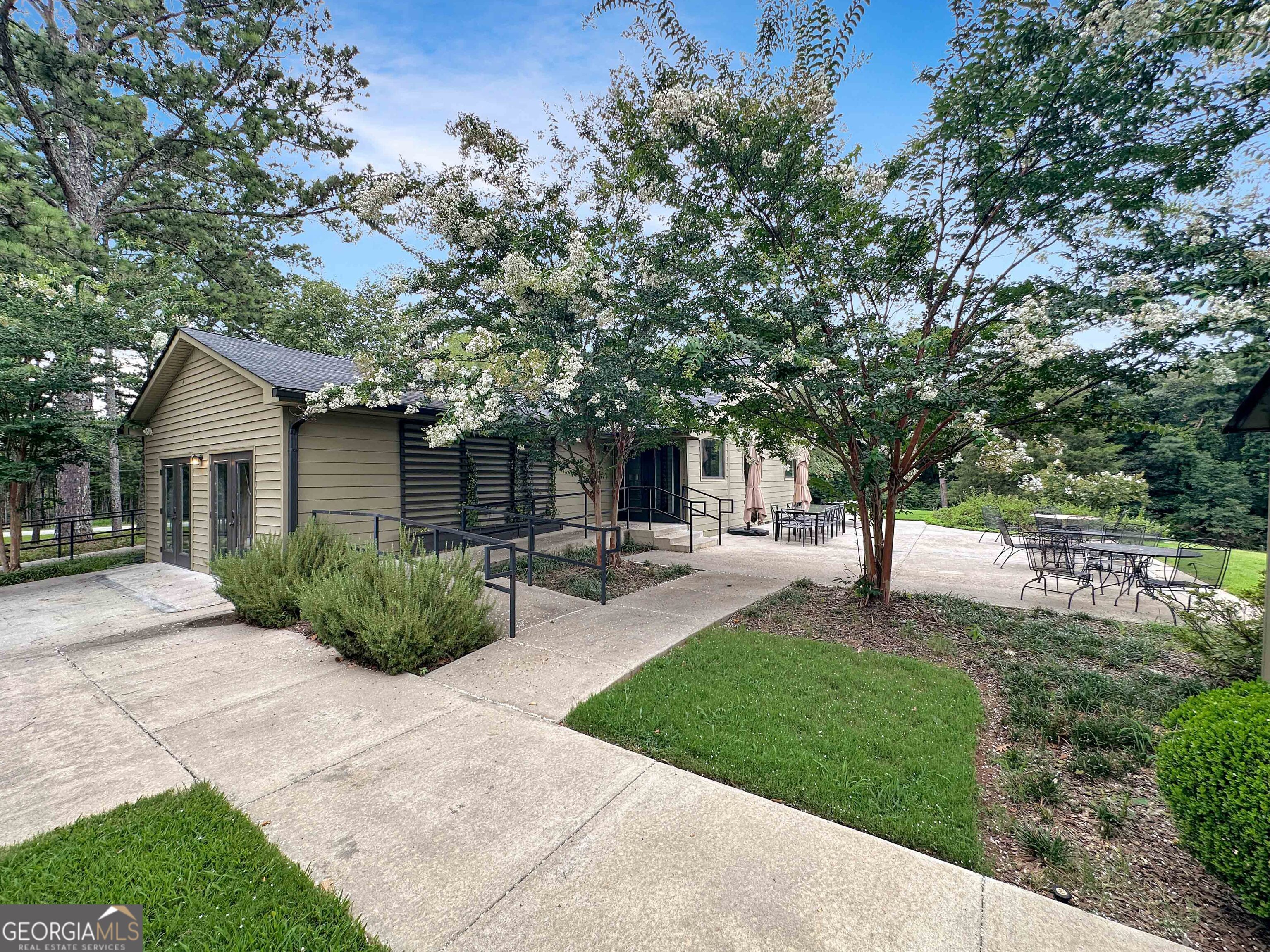 8400 Atlanta Newnan Road Chattahoochee Hills, GA 30268 - Photo 12 of 30 a front view of a house with a yard and trees