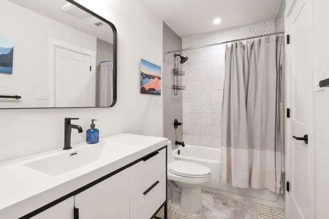 a bathroom with a sink a toilet and shower